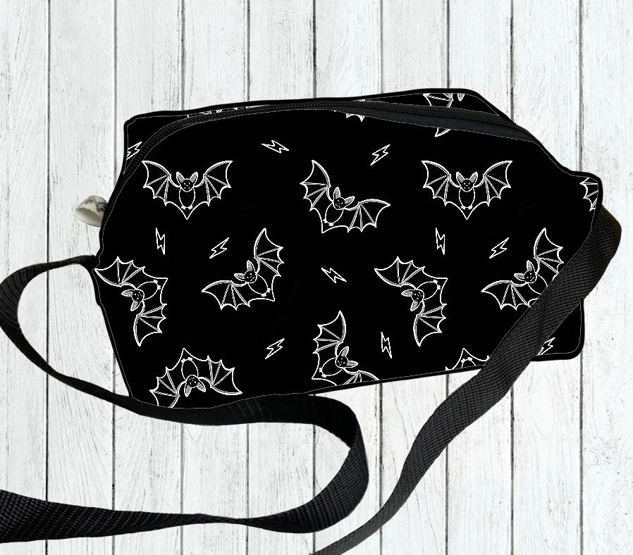 Bolsa preta com padrão de morcegos e raios em branco e alça preta