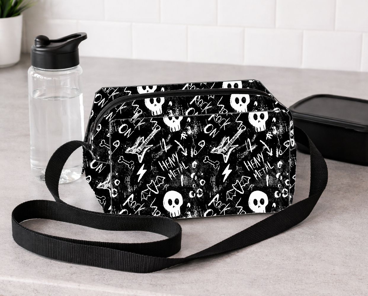 Bolsa preta com padrão de caveiras brancas e palavras Rock e Heavy Metal colocada sobre bancada cinza.