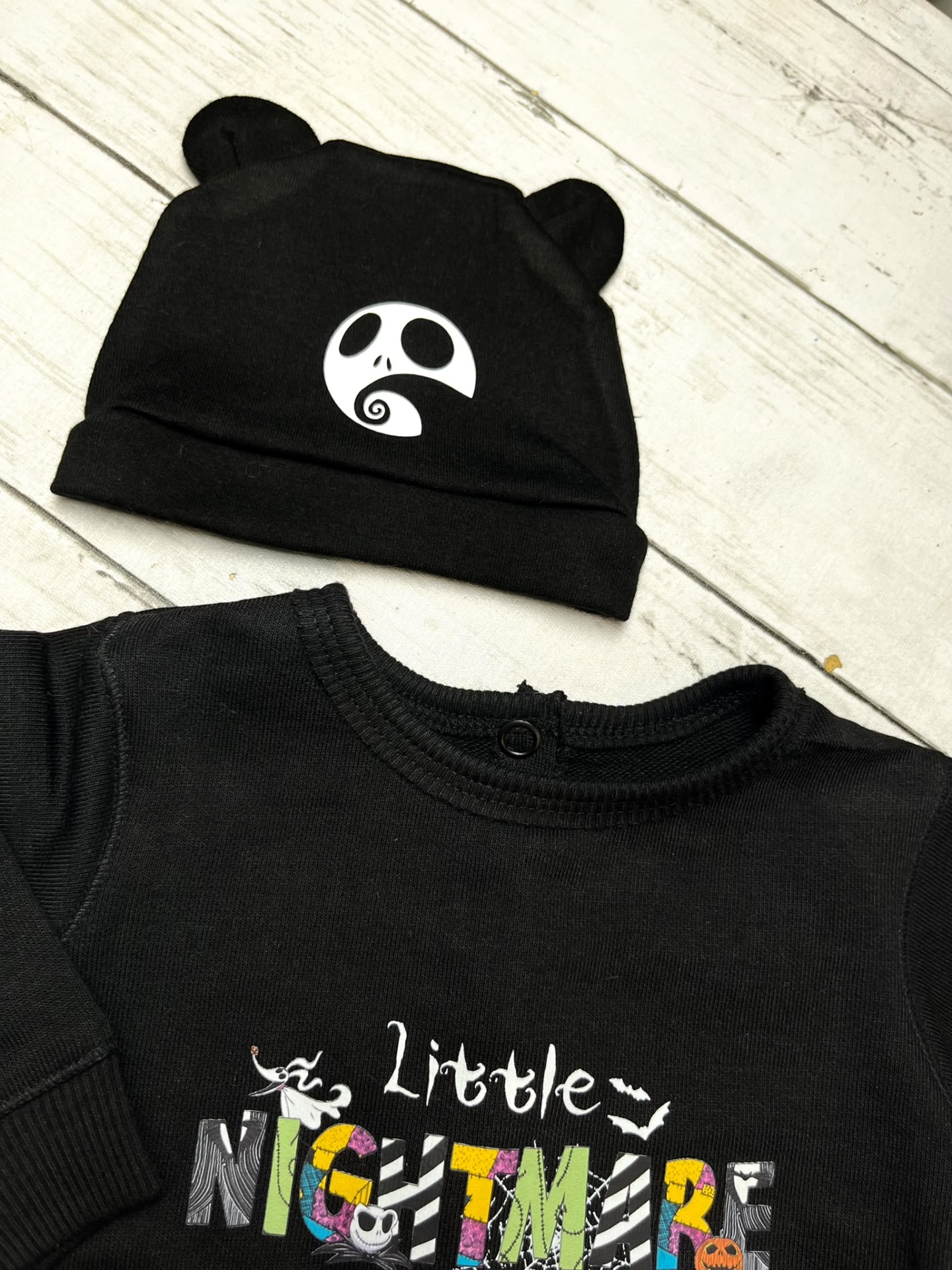 Conjunto de bebé preto com gorro de orelhas e camisola com estampa colorida