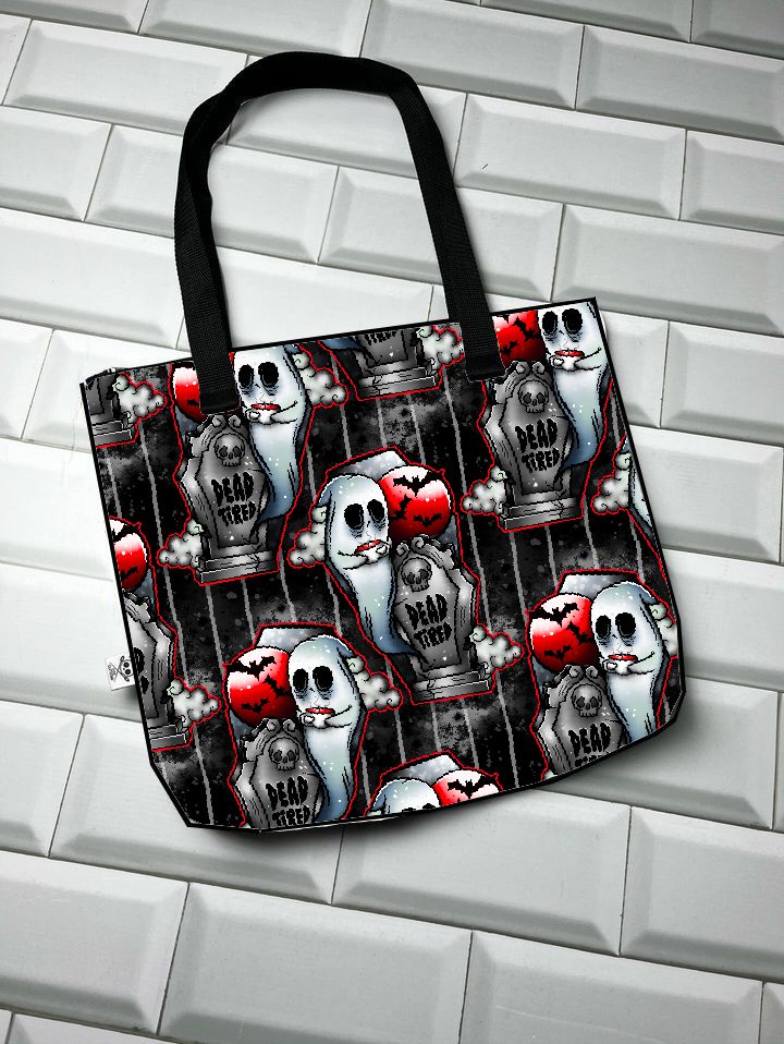 Saco de tecido com padrão de fantasmas, lápides e morcegos sobre fundo escuro