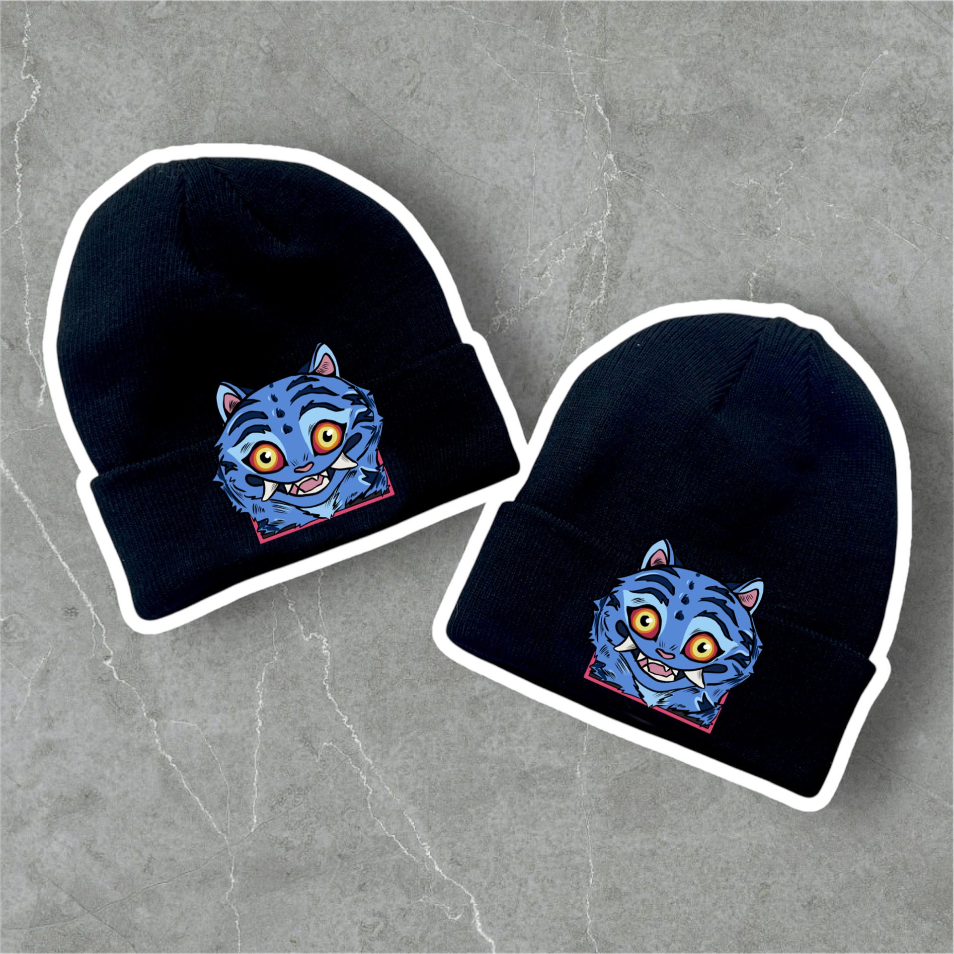 Dois gorros pretos com emblema de rosto de gato azul colorido.