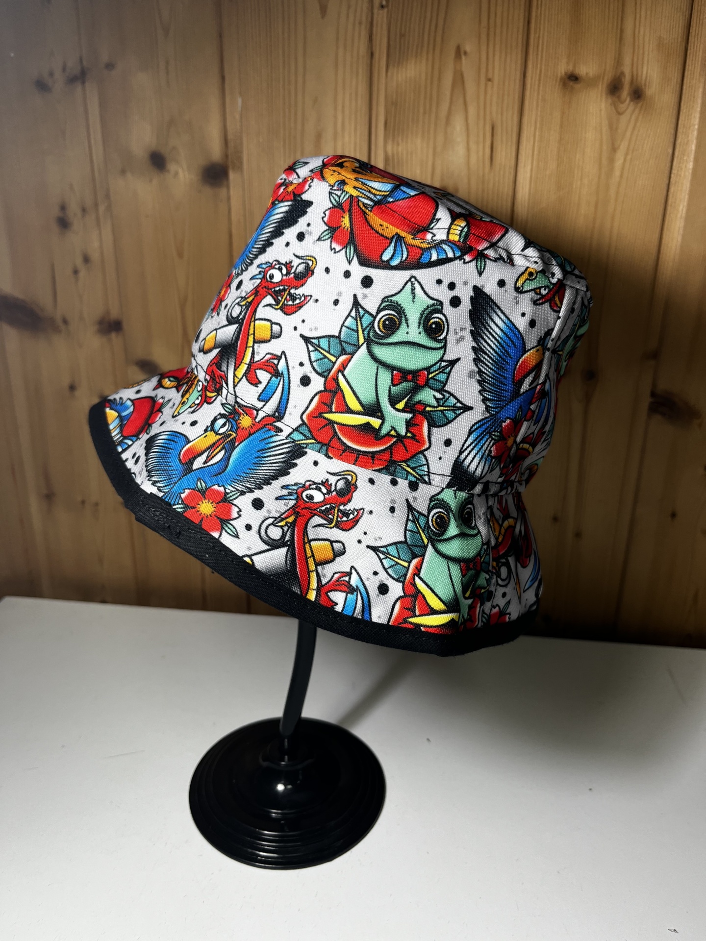 Chapéu bucket branco com padrão colorido de sapo, dragões, aves e flores