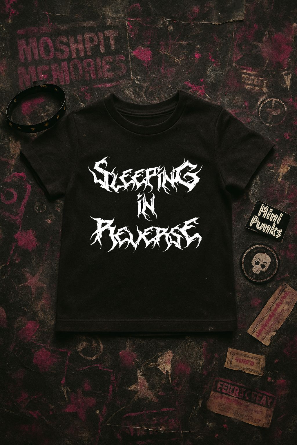 T-shirt preta com texto branco estilizado e acessórios sobre superfície escura com estampas.