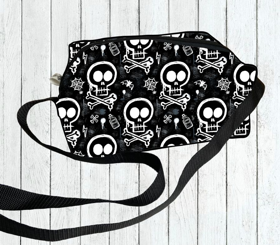 Mala preta com padrão de caveiras brancas e ossos cruzados