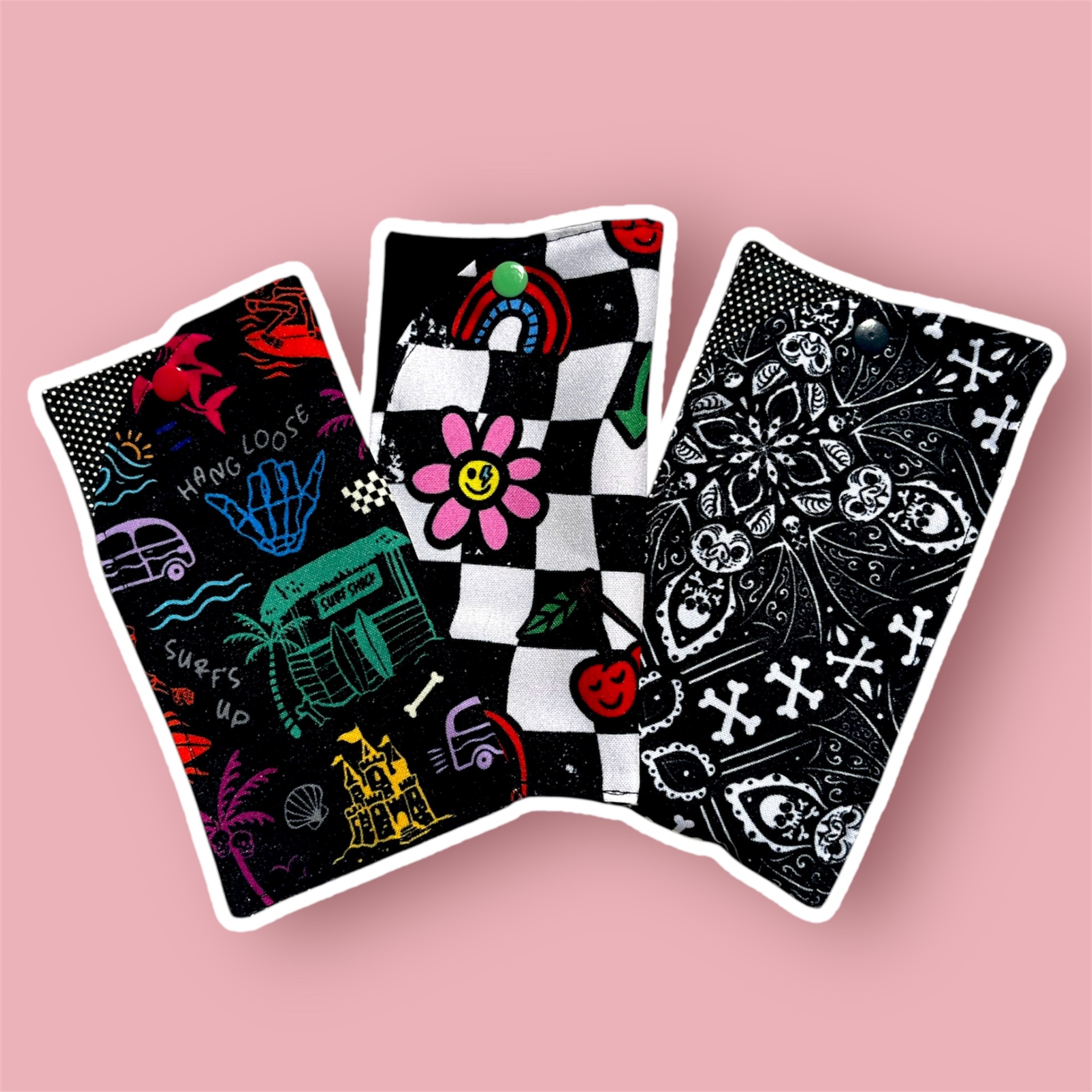 Três toalhas coloridas e com diferentes padrões sobre fundo rosa