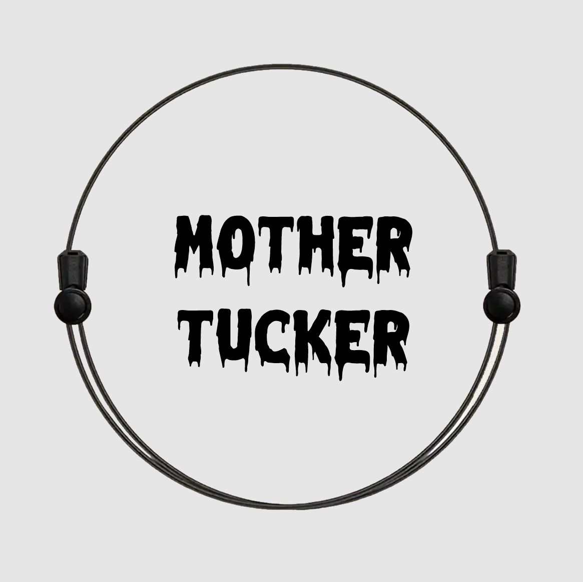 Anel metálico preto com frase 'MOTHER TUCKER' em letras pretas estilizadas