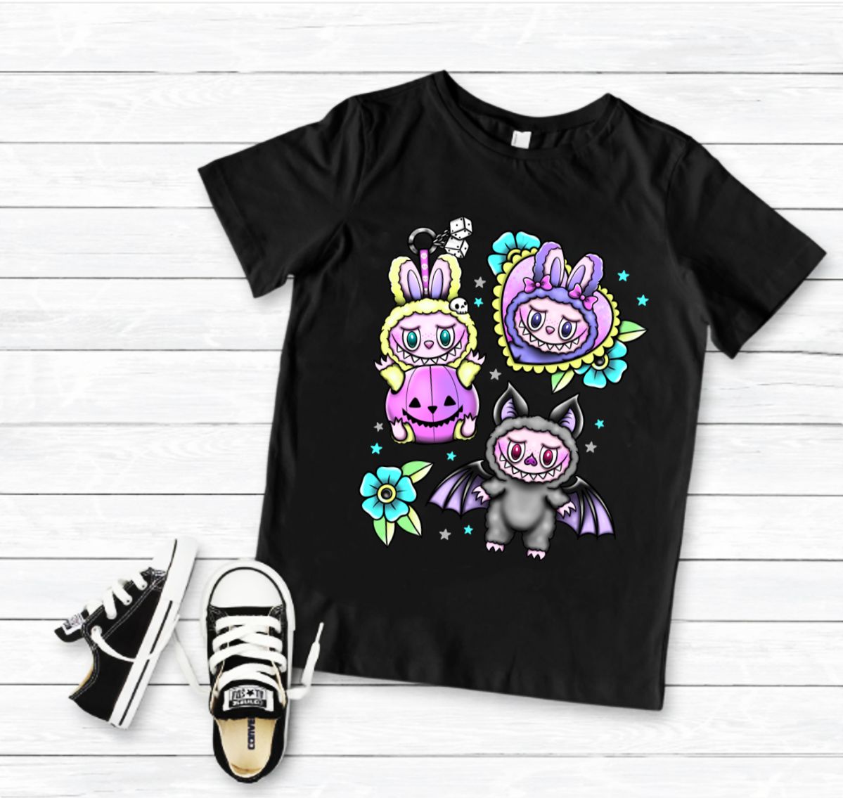 T-shirt preta com personagens de coelho e morcego em fundo de madeira branca