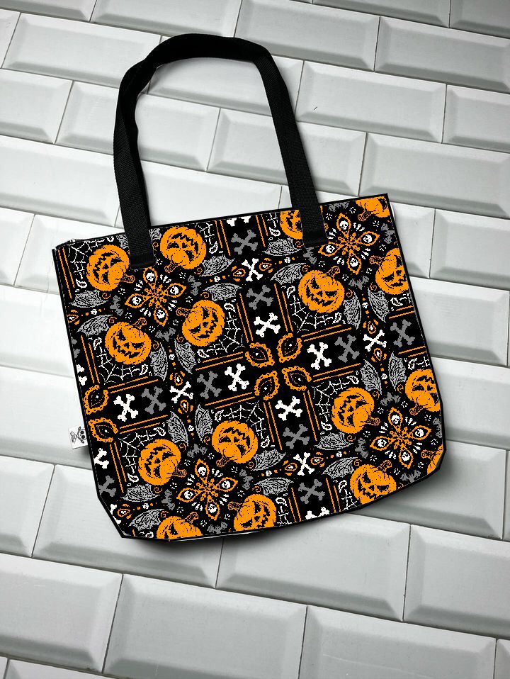 Sacola preta com padrão de abóboras laranja e caveiras brancas