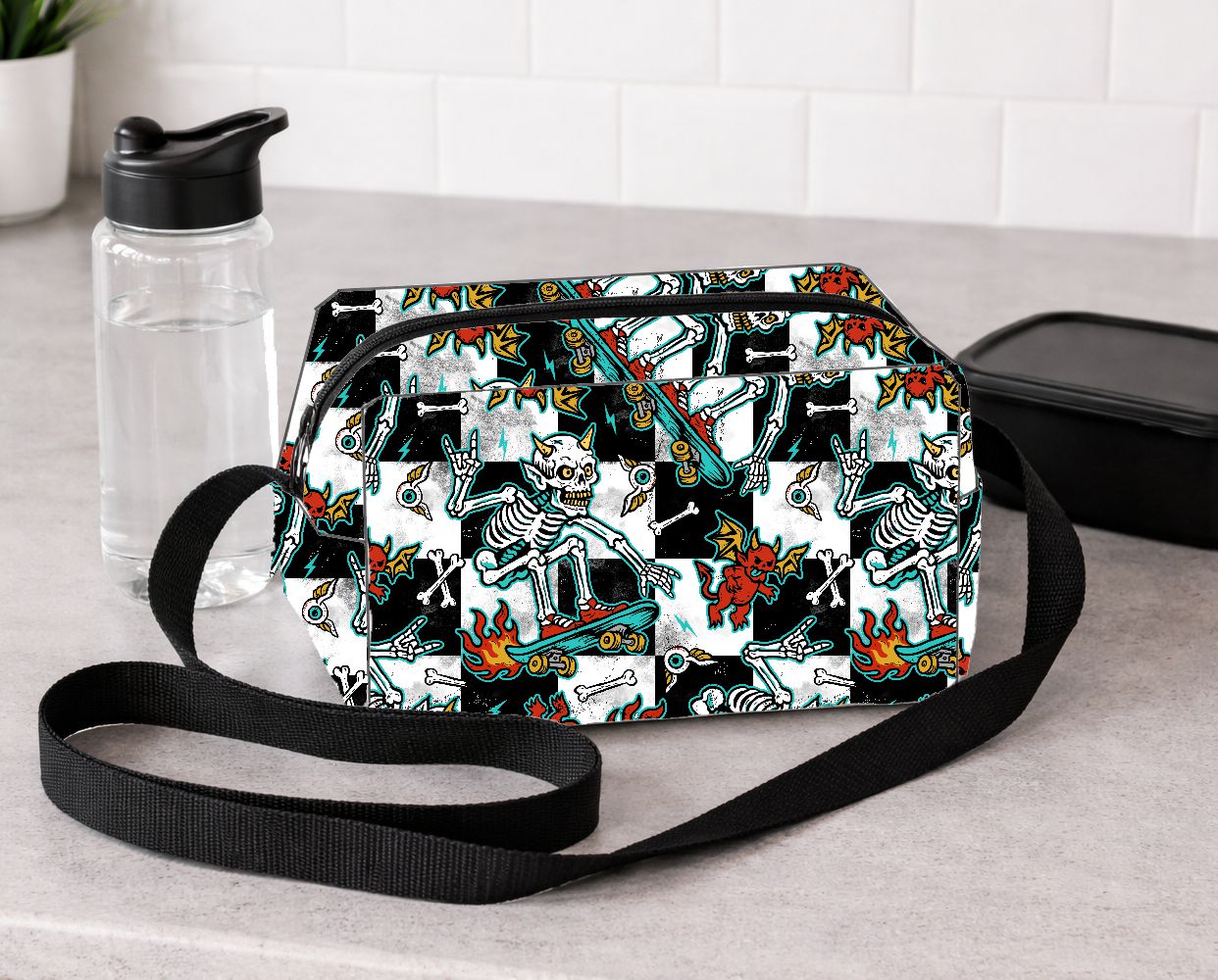 Bolsa com padrão colorido de esqueletos e criaturas em fundo preto e branco.