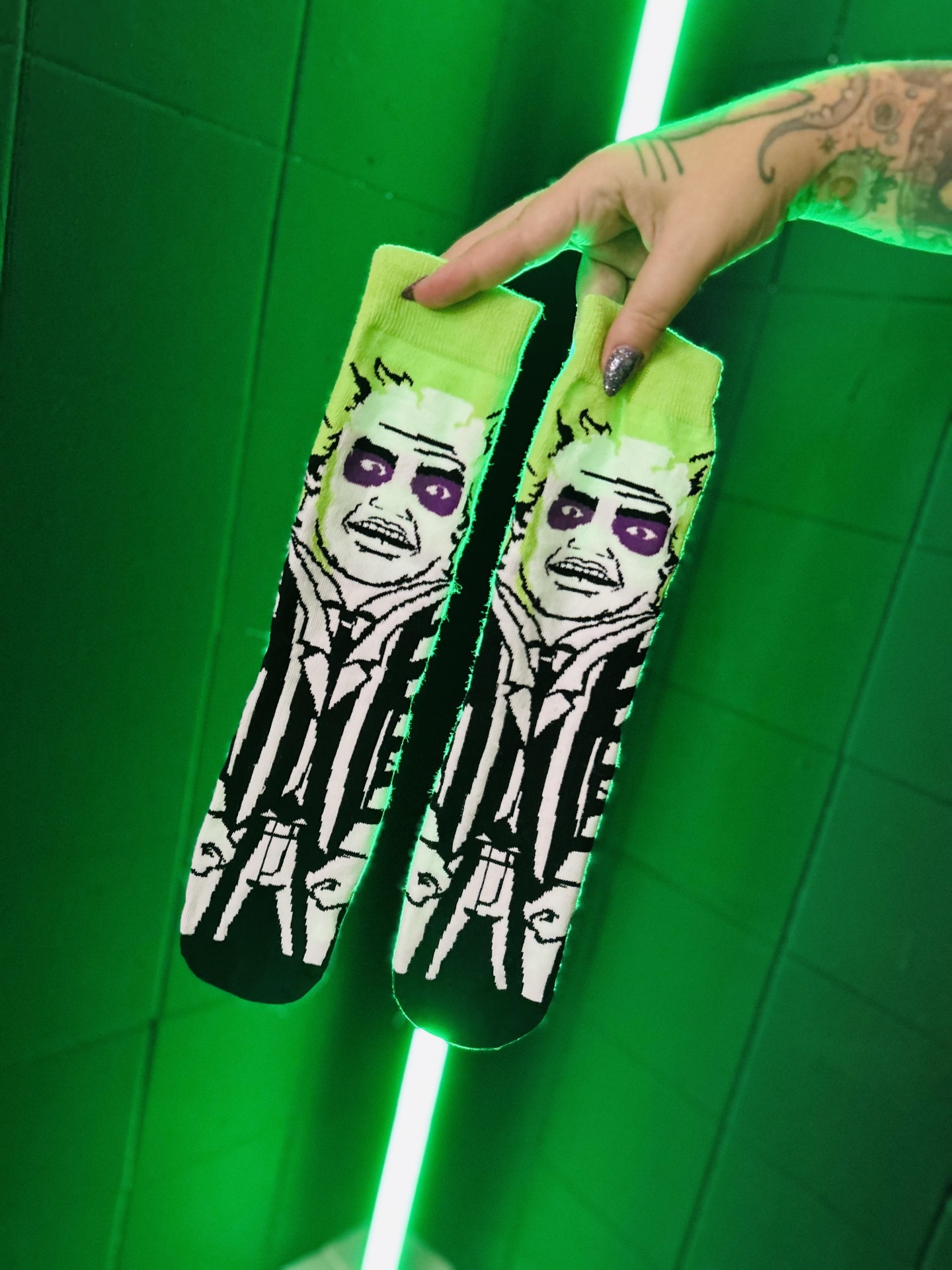 Meias estampadas com rosto e cabelo verde-limão em fundo verde neon