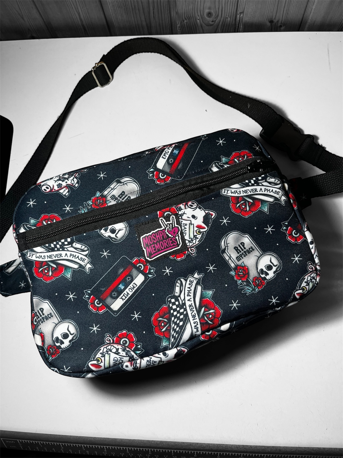 Bolsa tiracolo preta com padrão colorido e fecho de correr preto