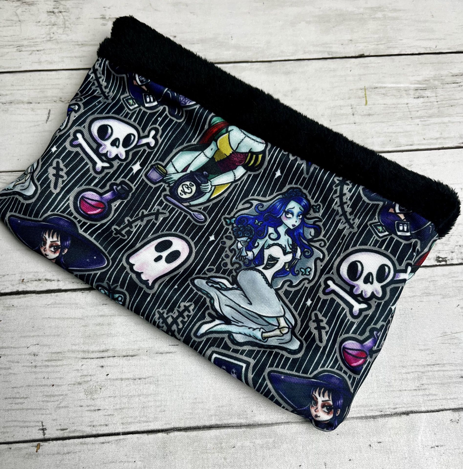 Bolsa estampada preta com desenhos de caveiras e personagens em estilo cartoon