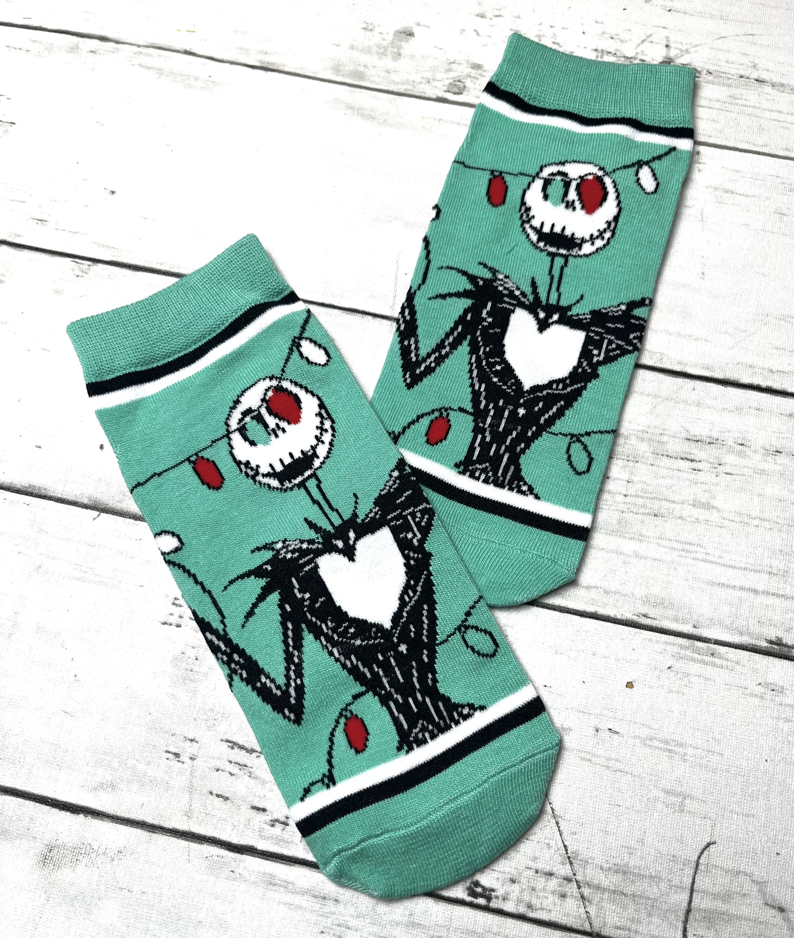 Meias verdes com desenho de personagem esquelético e luzes coloridas