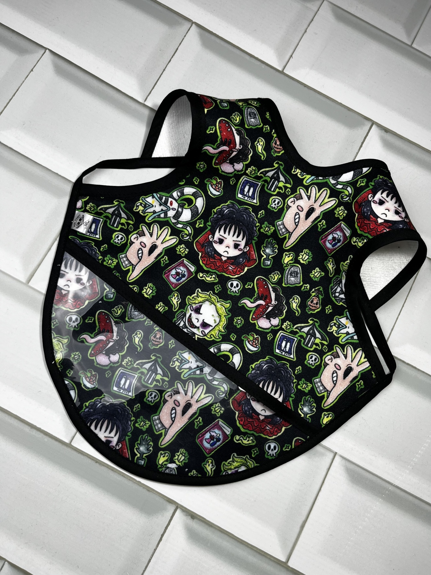 Babete colorido para criança com estampado de personagens e bolso plástico