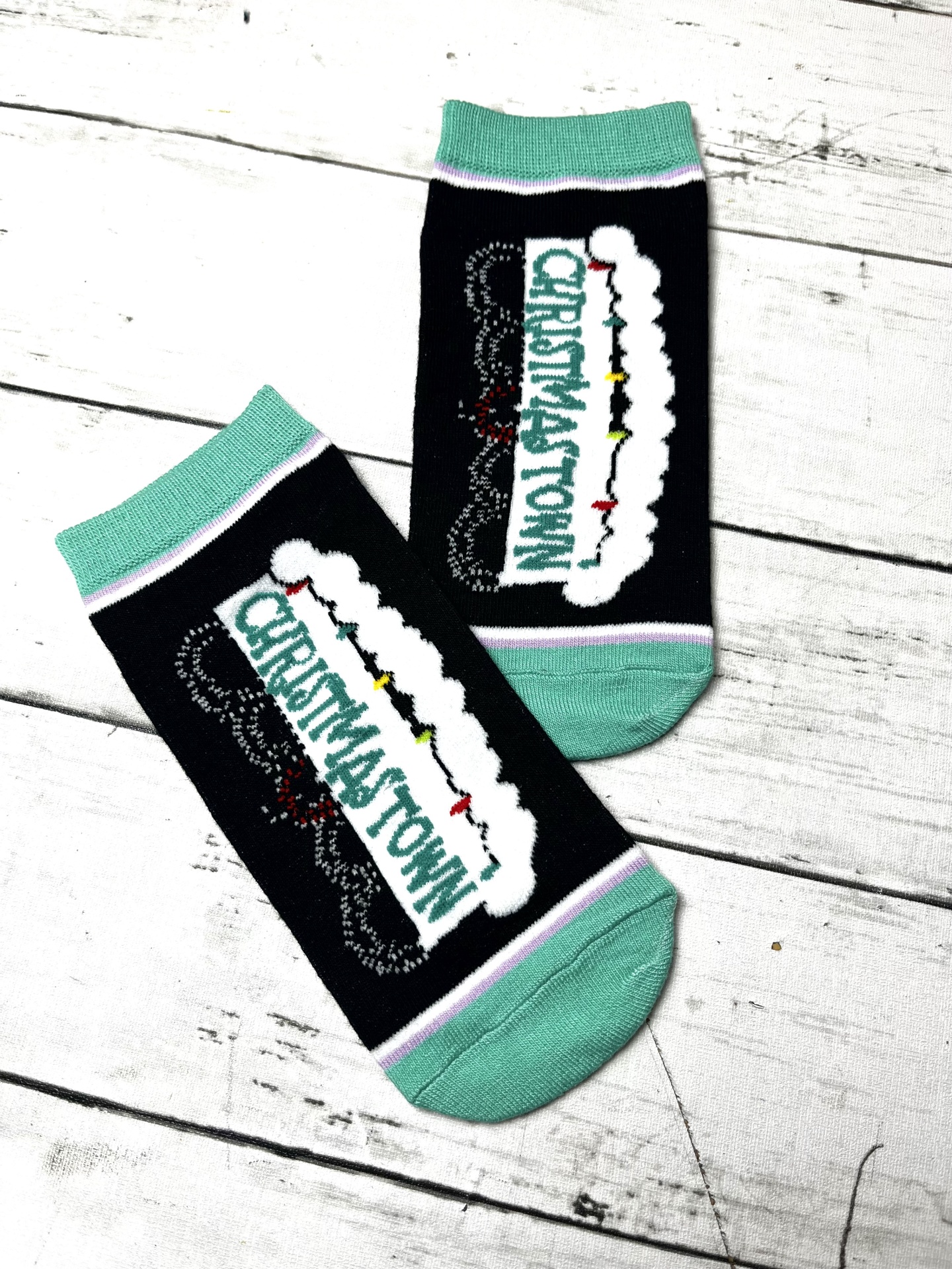 Par de meias pretas com detalhes verdes e palavras Christmas Town