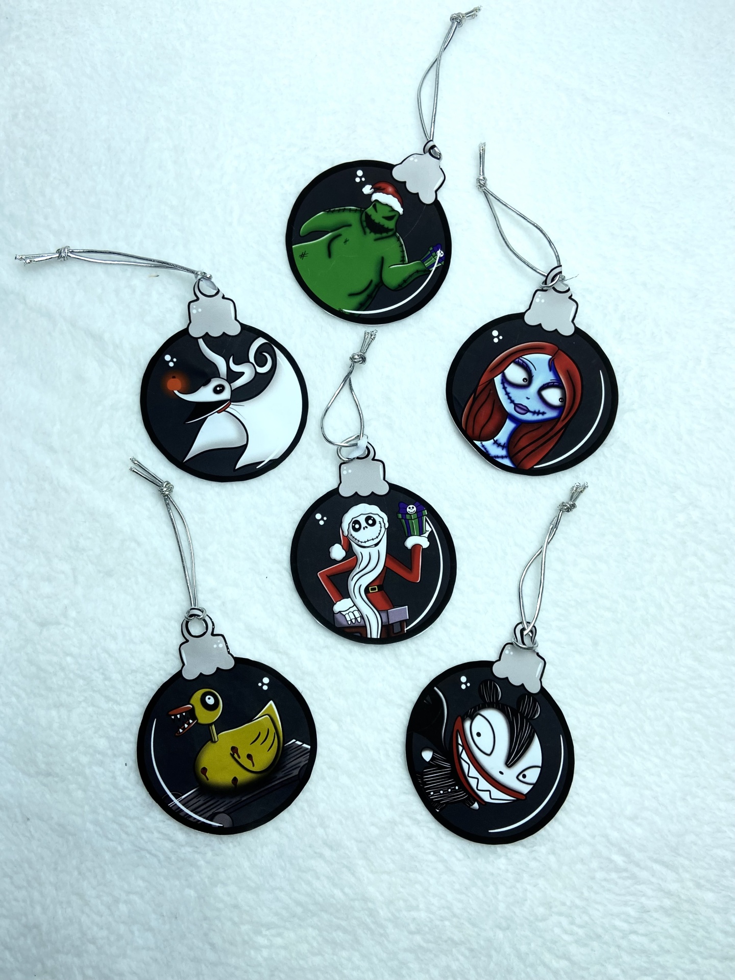 Ornamentos de Natal redondos pretos com personagens animadas e cordões prateados