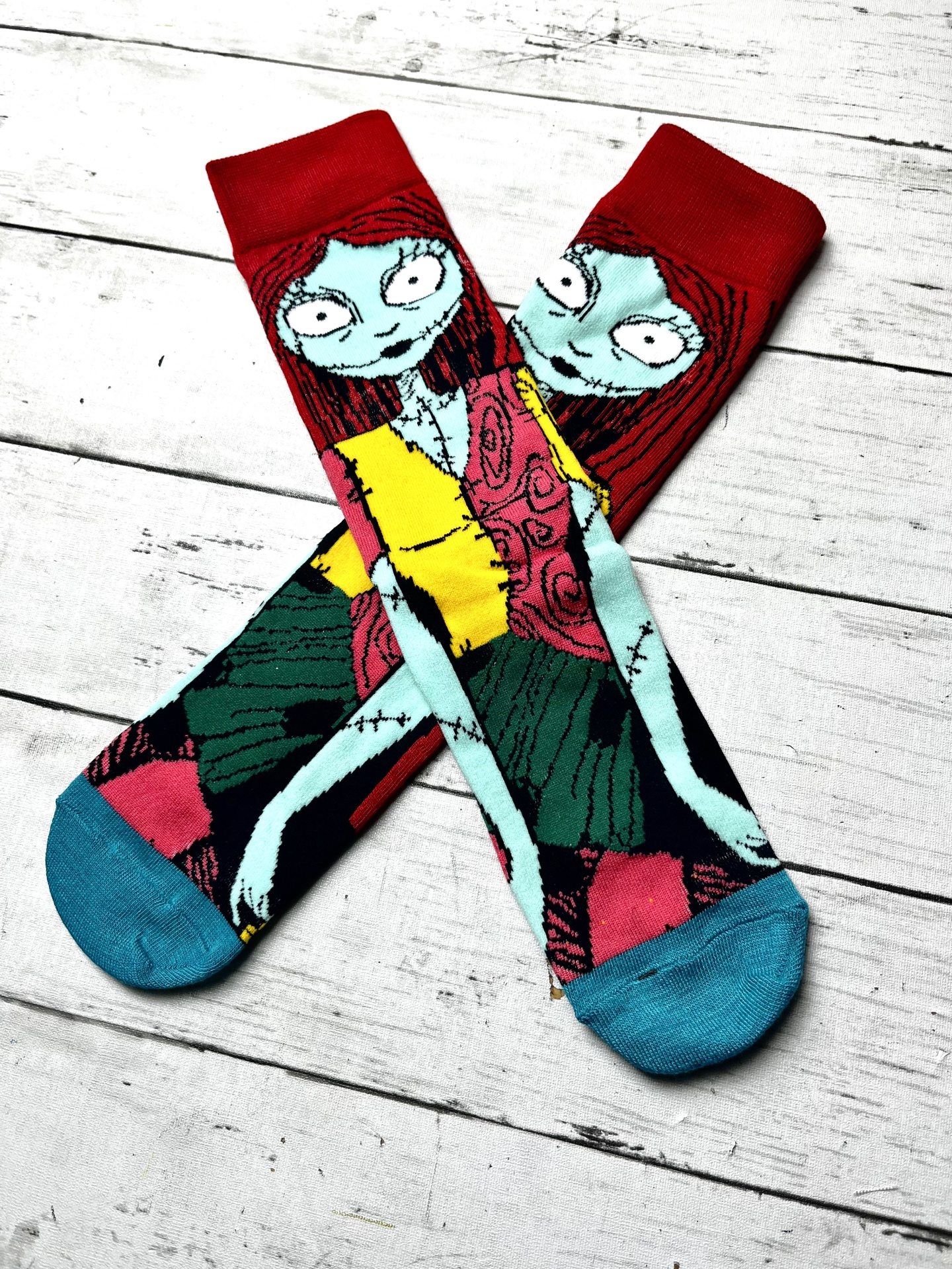 Meias coloridas com estampa de personagem de cartoon sobre fundo de tábuas brancas