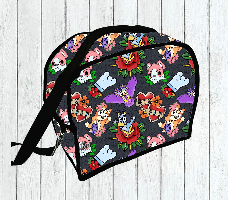 Mala pequena preta com padrão colorido de tatuagens e desenhos cartoon sobre fundo de madeira branca