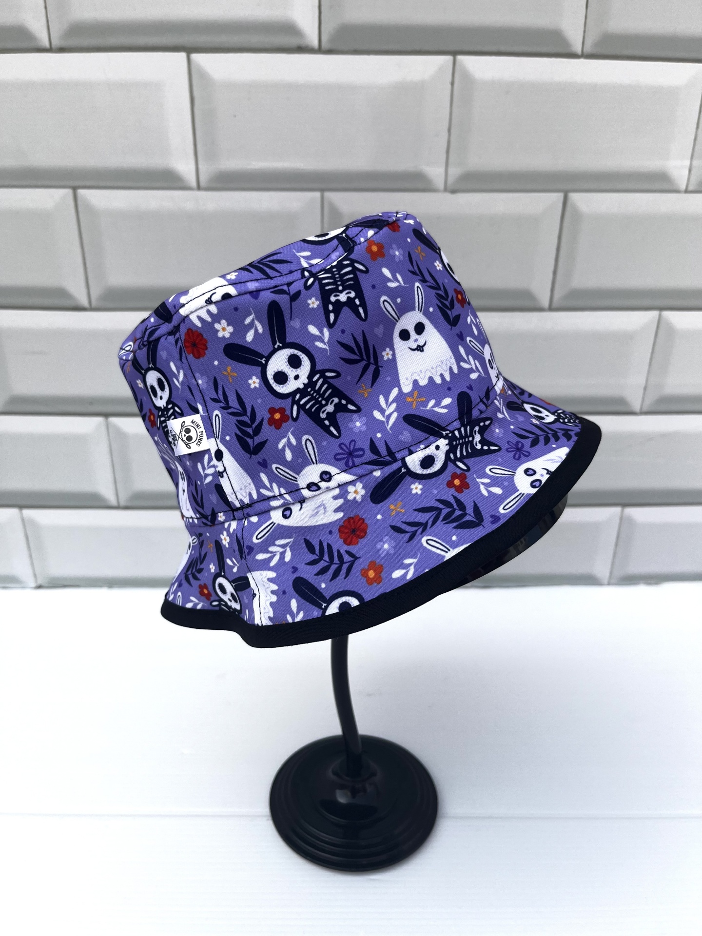 Chapéu bucket azul com padrão de coelhos e esqueletos