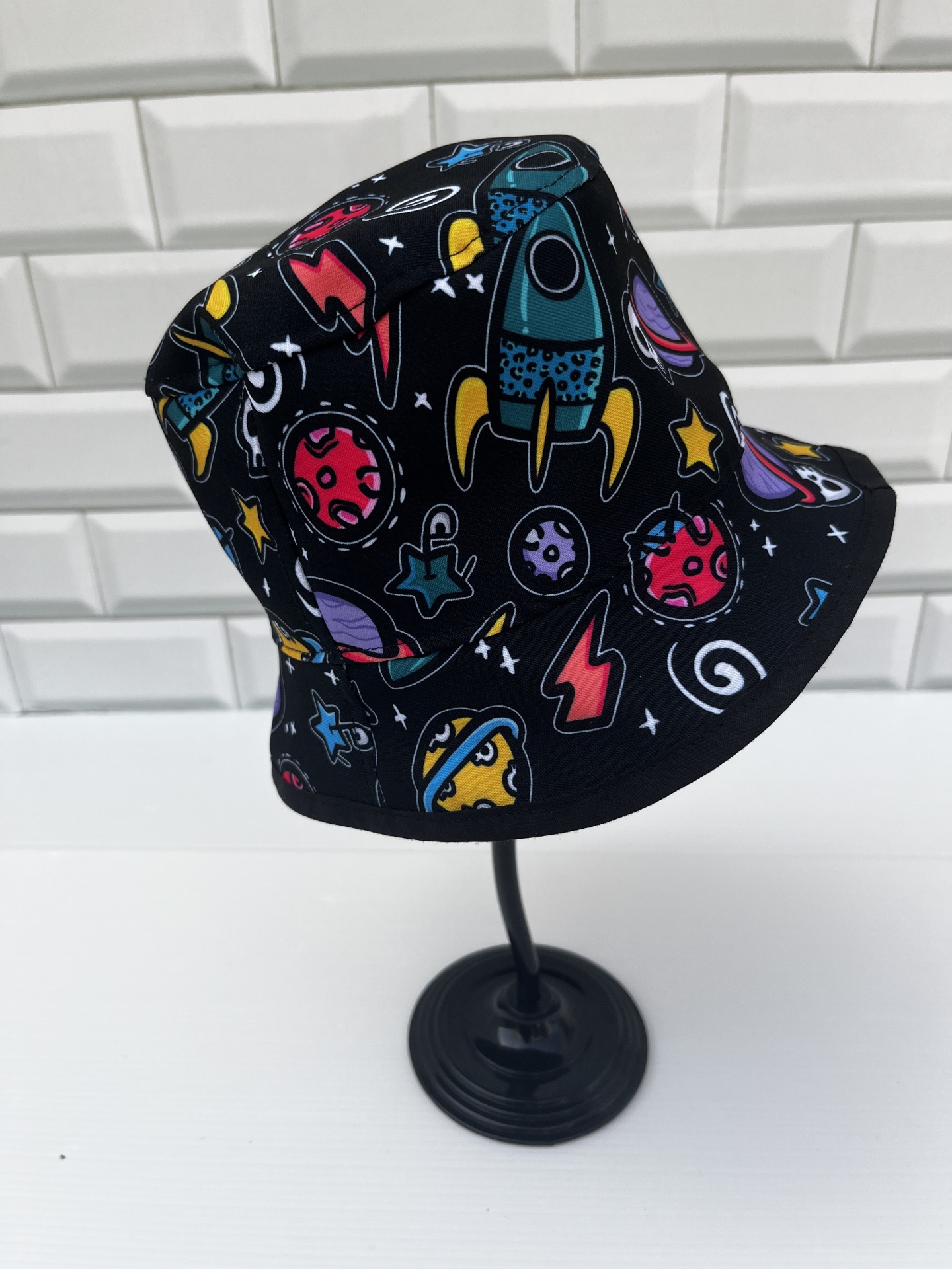 Chapéu de pescador com estampas espaciais coloridas em fundo preto