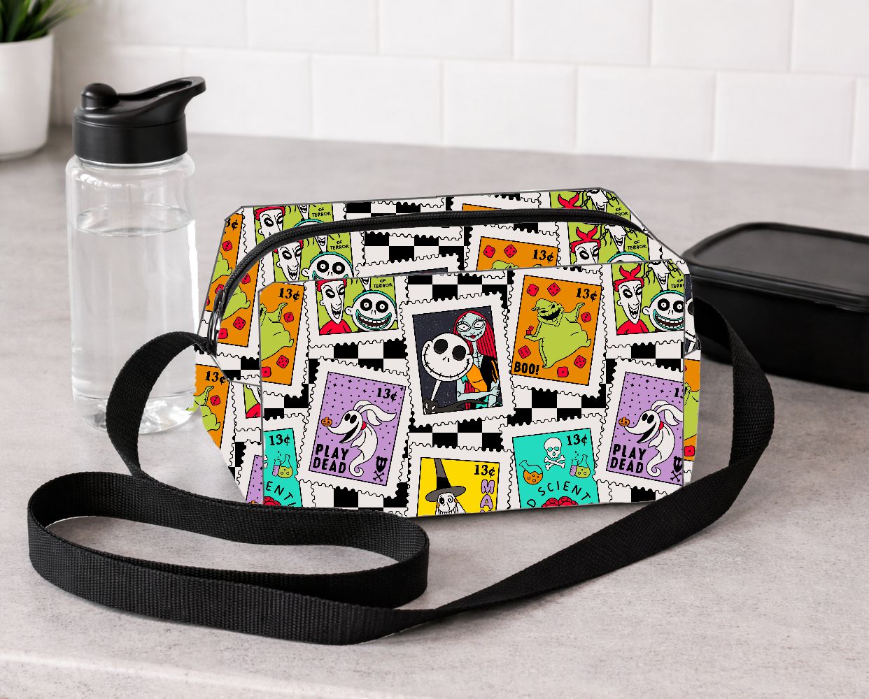 Mala pequena colorida com padrão de selos postais e acessórios num balcão