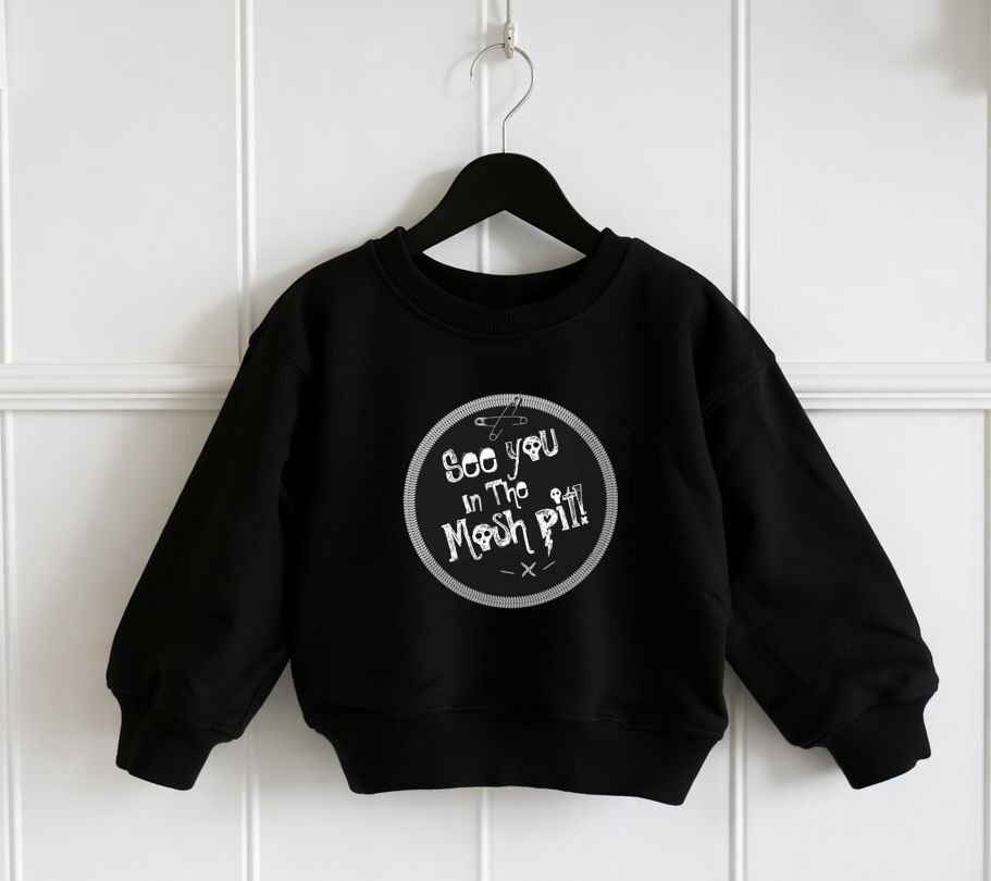 Sweatshirt preta de criança com padrão branco e texto em frente, pendurada num cabide