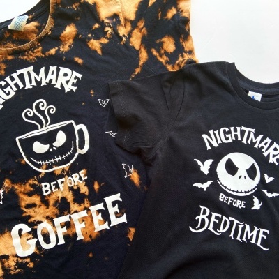 Duas t-shirts pretas com estampados brancos e padrão tingido laranja numa delas