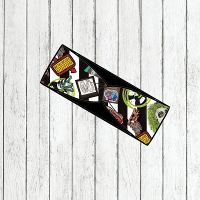 Carteira preta de couro com ilustrações coloridas e frases em inglês sobre superfície de madeira clara