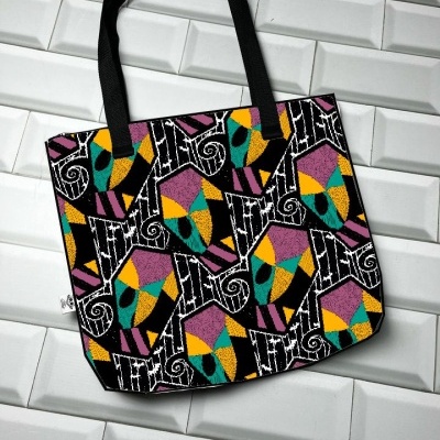 Saco de tecido colorido com padrão geométrico sobre fundo branco azulejado