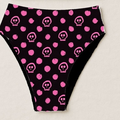 Cueca preta com padrão cor-de-rosa de caveiras e bolinhas sobre fundo bege