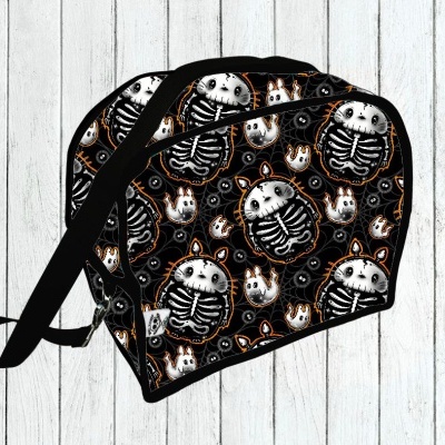 Mochila preta com padrão de esqueletos de ursos, alça preta, sobre piso de madeira branca