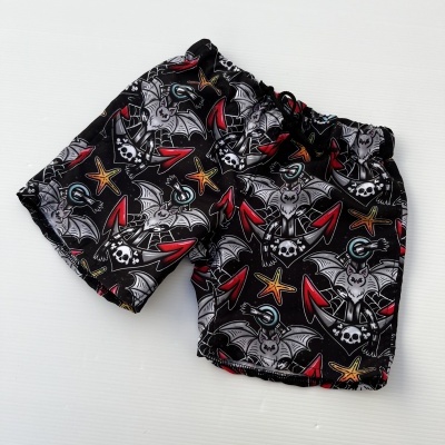 Calções pretos com padrão colorido de morcegos e caveiras
