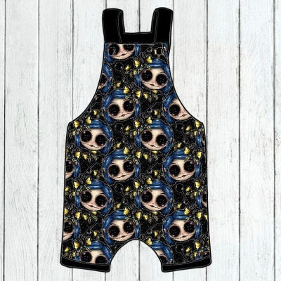 Jardineira para criança com padrão de rostos de bonecas em tecido