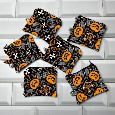 Acessórios de tecido Halloween preto, branco e laranja sobre azulejos brancos