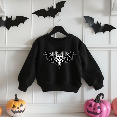Sweatshirt preta com estampa de morcego esqueleto pendurada entre decoração temática de Halloween.