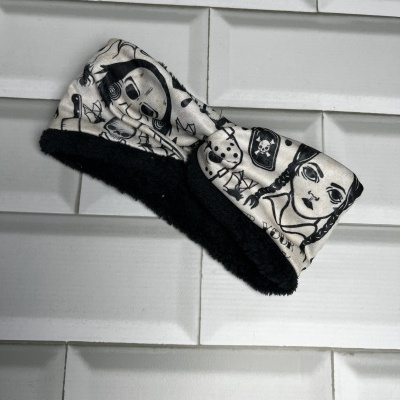 Faixa de tecido com padrão desenhado a preto e branco, com interior felpudo preto