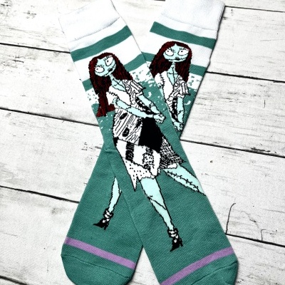 Par de meias com personagem animada de cabelo vermelho e vestido preto e branco