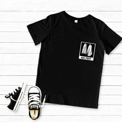 T-shirt preta com estampa branca de dois fantasmas e texto NO FEET ao lado de sapatos infantis pretos