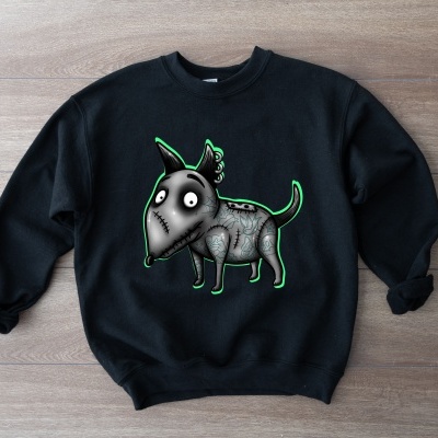 Sweatshirt preta com desenho de cão cinzento e verde sobre fundo de madeira