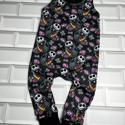 Macacão de criança com padrão de caveiras e orelhas de coelho cor-de-rosa