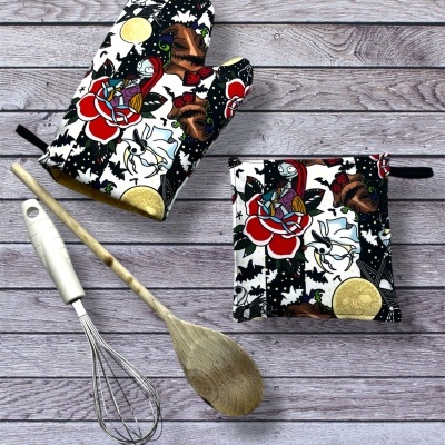 manopla e pega de cozinha com padrão colorido e utensílios de cozinha sobre madeira