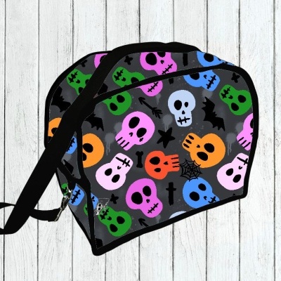 Bolsa tiracolo com padrão colorido de caveiras sobre fundo cinzento