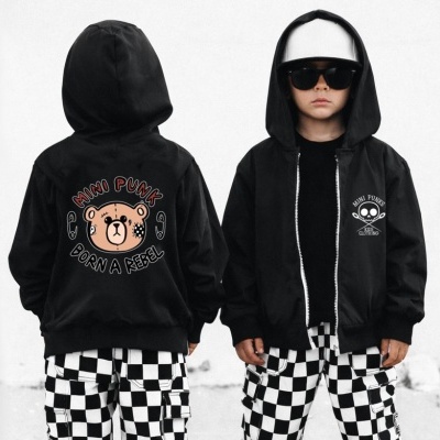 Casaco preto com estampas de urso e texto, calças quadriculadas pretas e brancas em criança com boné e óculos.