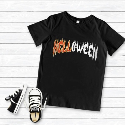 T-shirt preta com texto Halloween e sapatilhas negras sobre fundo de madeira clara.
