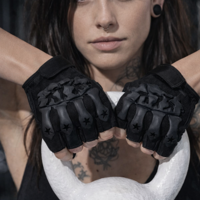 Mulher com luvas pretas de treino segurando kettlebell branco no ginásio