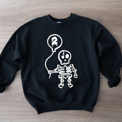 Sweatshirt preta com estampa de esqueleto branco segurando balão
