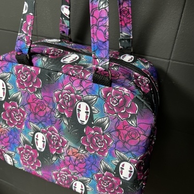 Mala colorida com padrão de flores e máscaras brancas em tecido sintético