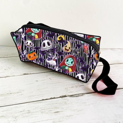 Bolsa retangular colorida com padrão de personagens assustadores em fundo roxo e preto.