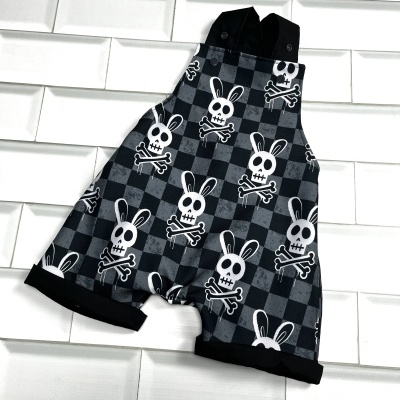 Macacão curto cinza e preto com padrão de caveiras de coelho e alças pretas