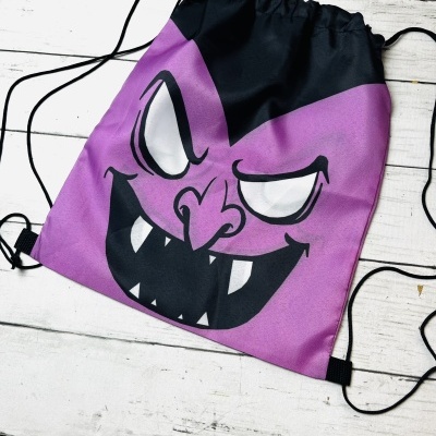 Saco mochila roxo com rosto malicioso desenhado